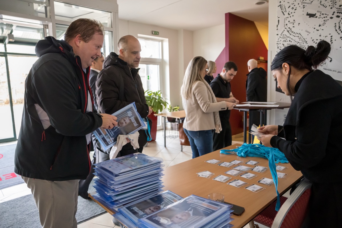 Účastníci si preberajú konferenčné materiály